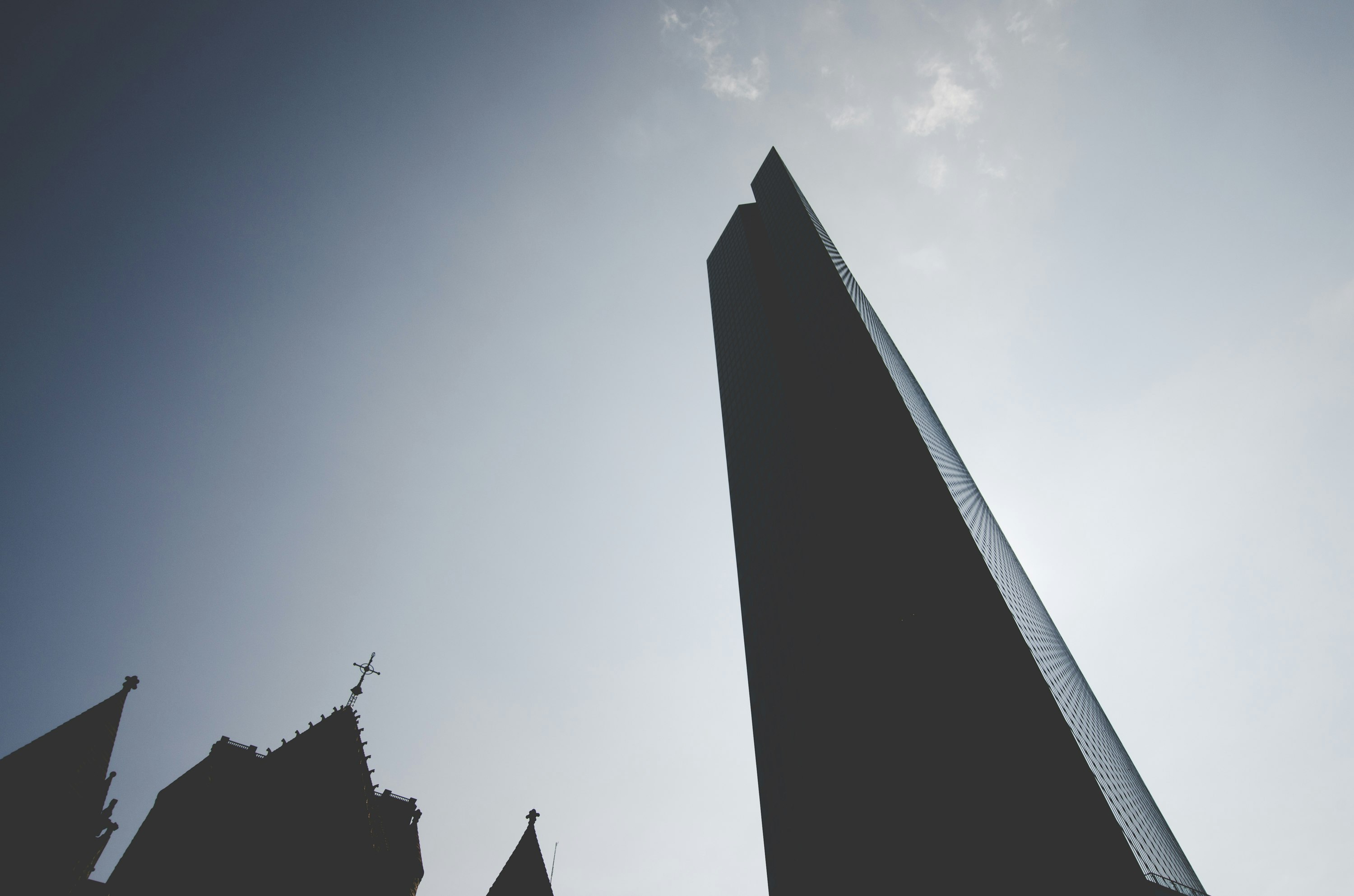 grey cathedral and high-rise building under grey sky